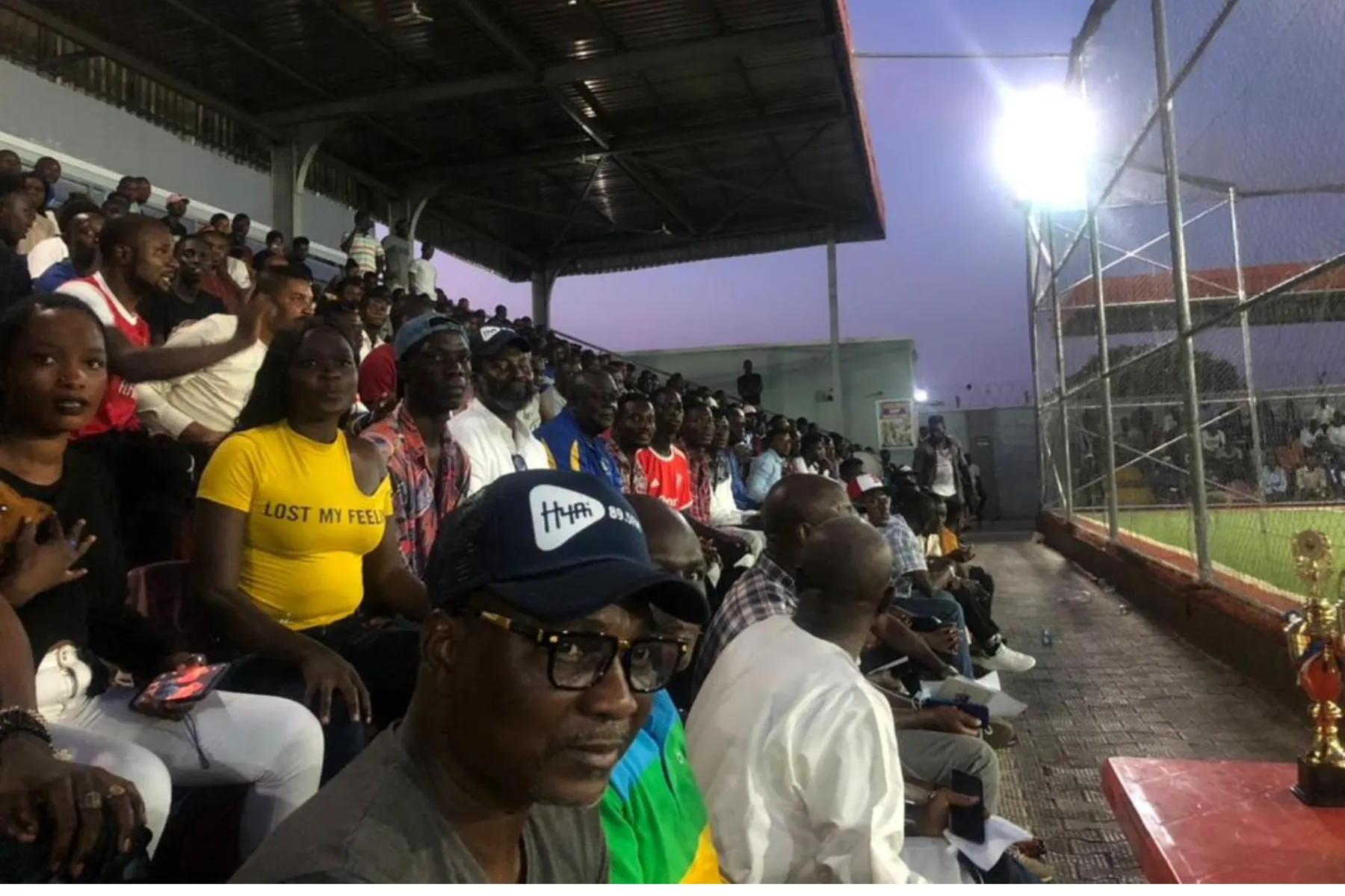 Spectators watching a Croc City Soccer League match beside the pitch